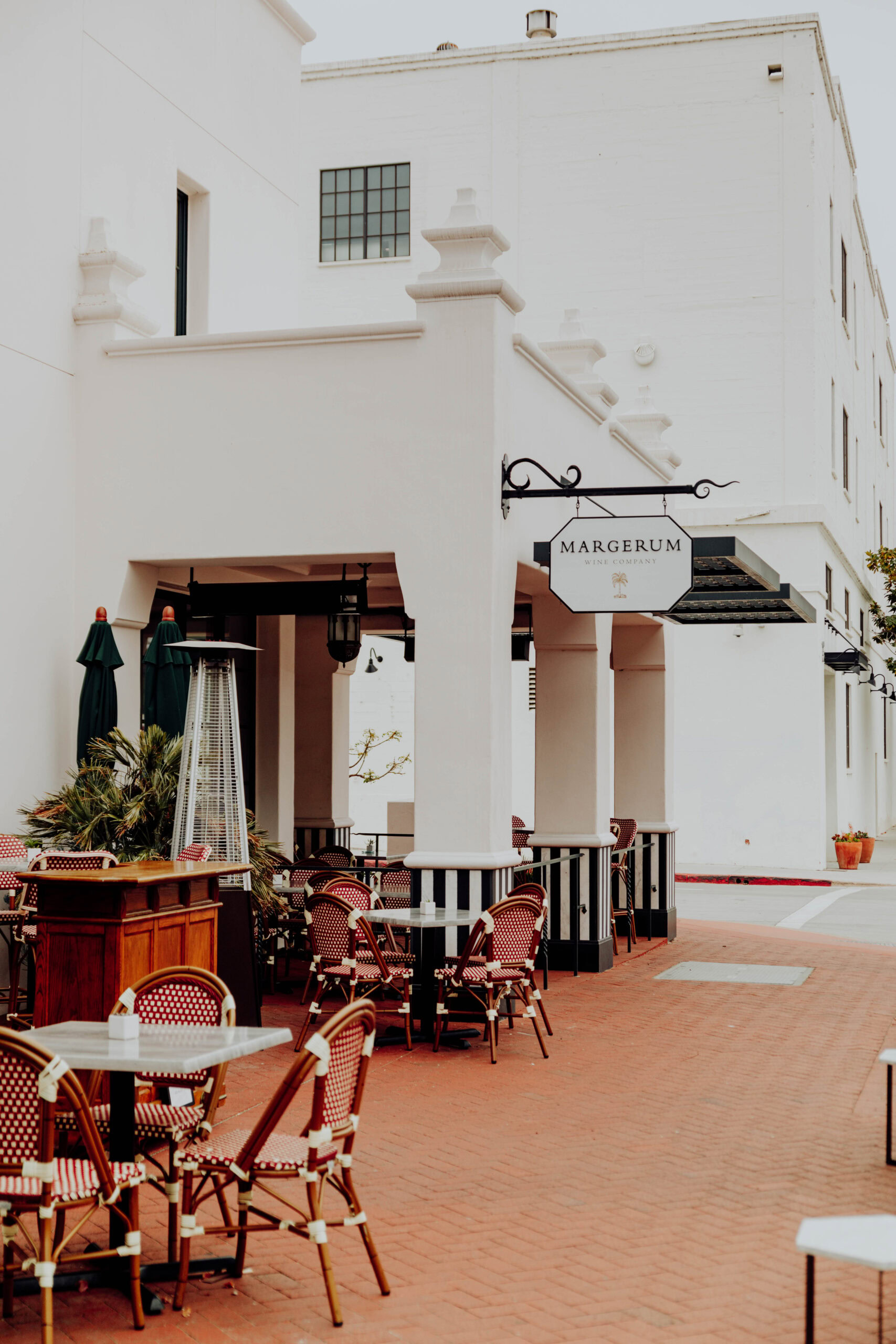 the exterior of Margerum's tasting room with the margerum sign, and patio visibile. the patio has two tables and a host stand visible.