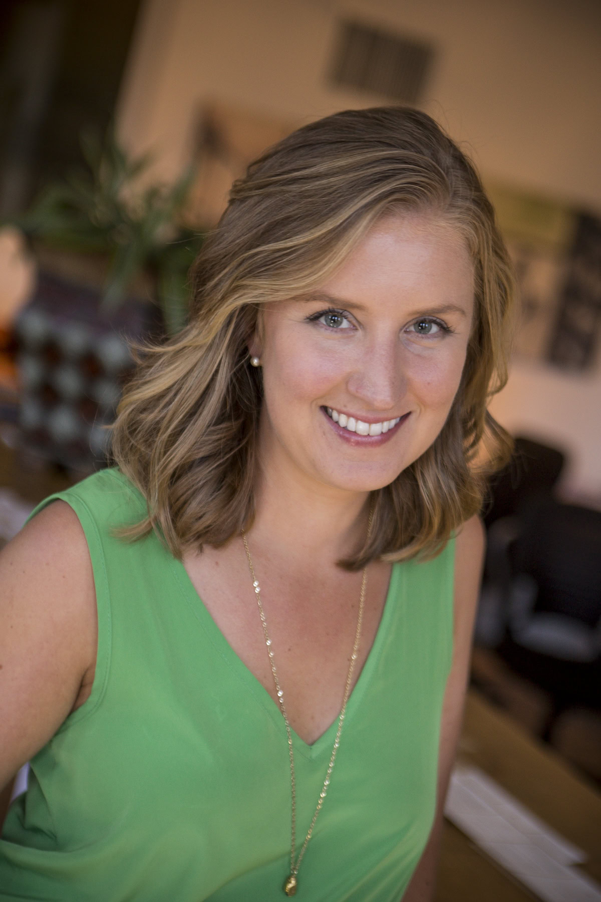 headshot of smiling woman in green shirt