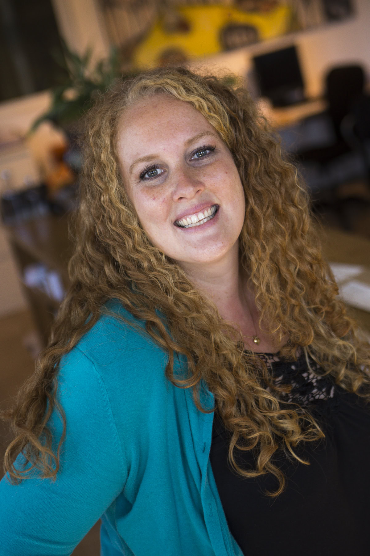 headshot of smiling woman in teal cardigan